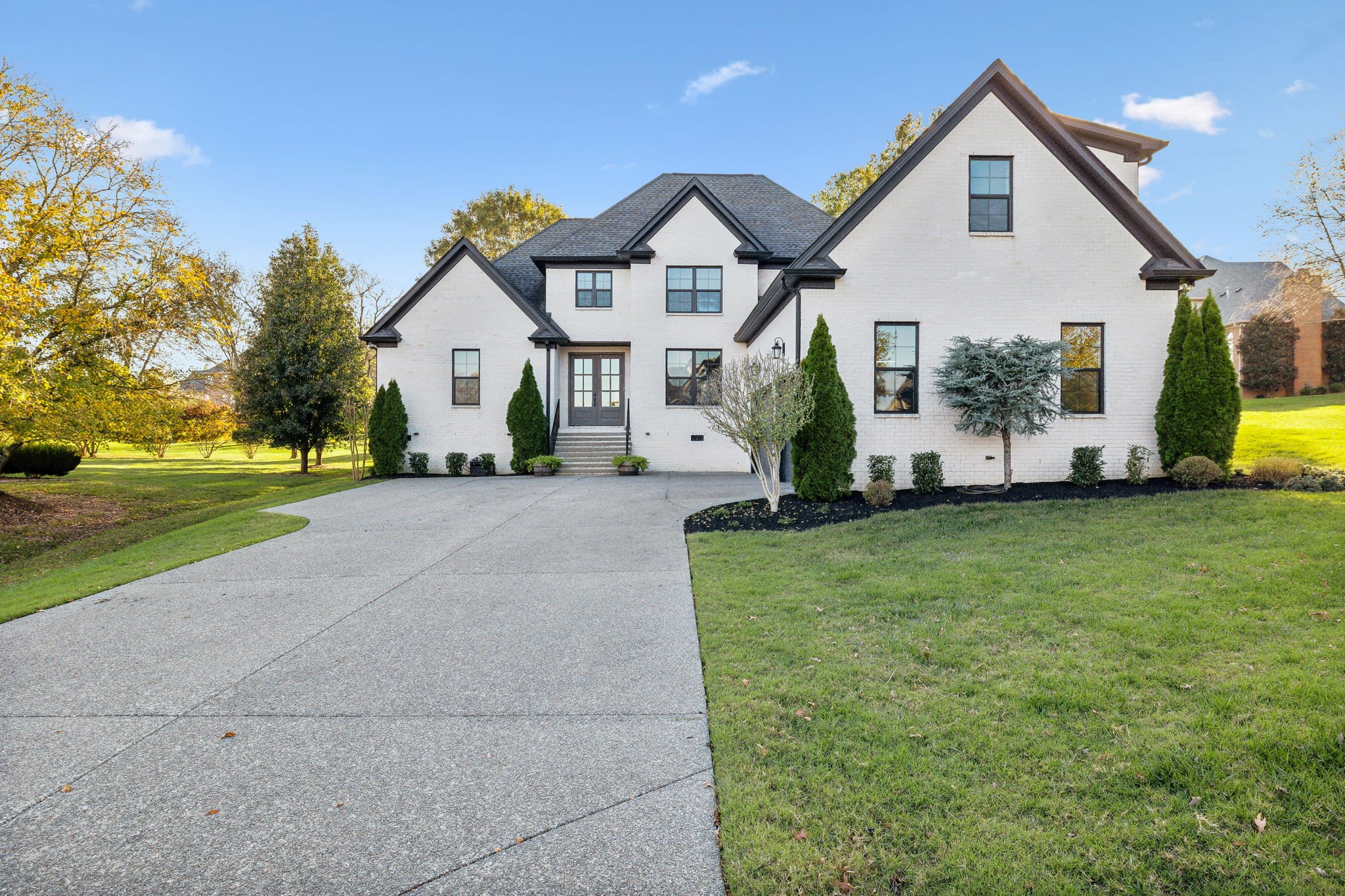 a front view of a house with a garden and plants