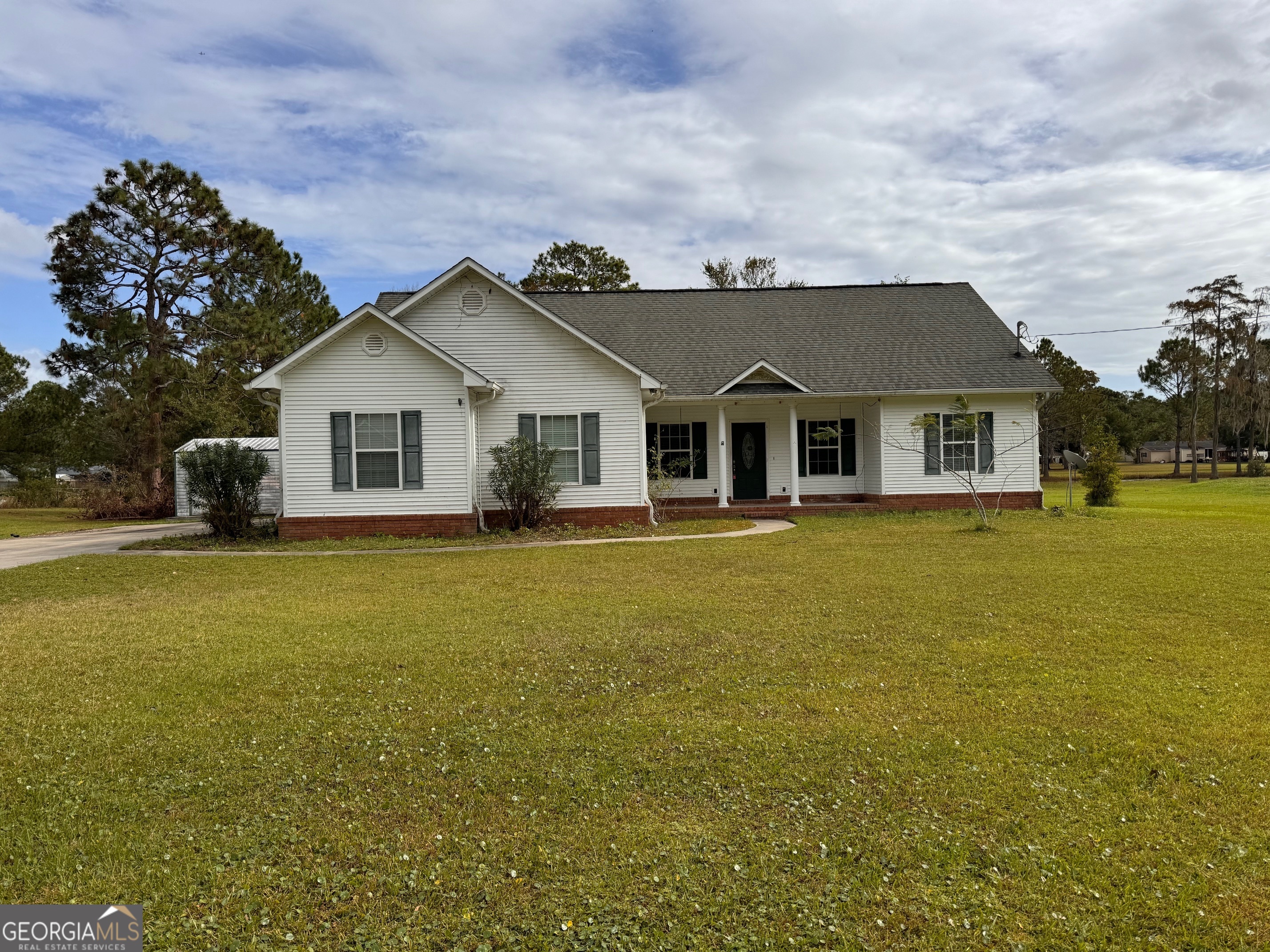 a front view of a house with a garden and yard