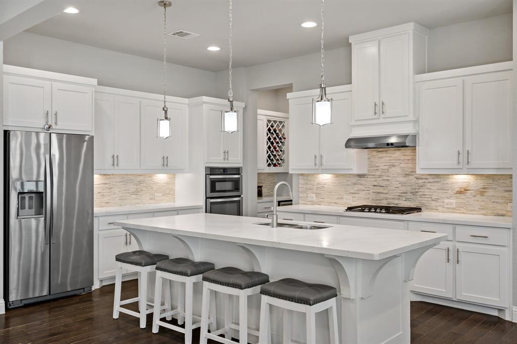 a kitchen with stainless steel appliances granite countertop a sink and a refrigerator