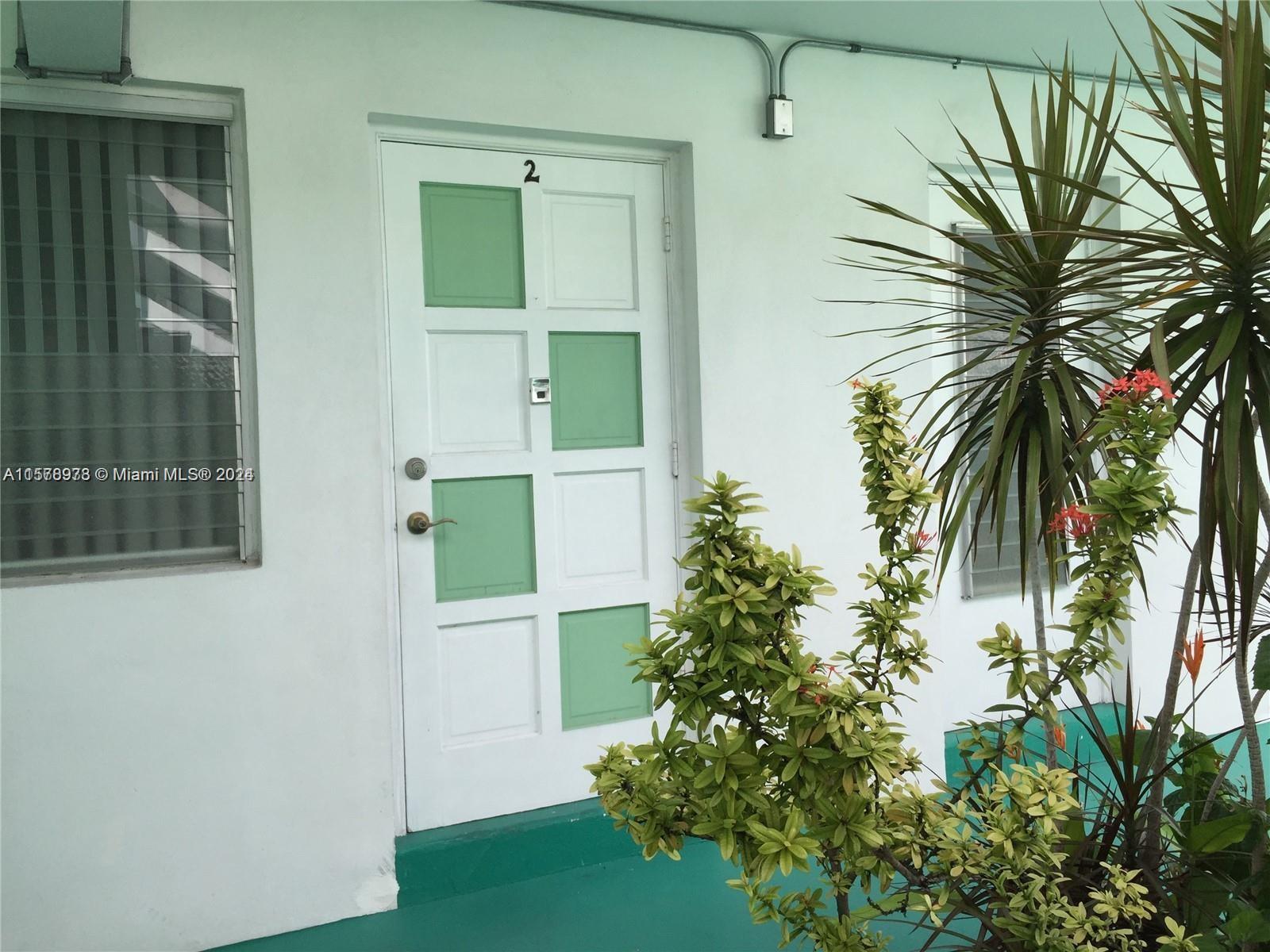 a view of a house with a plants and a palm tree