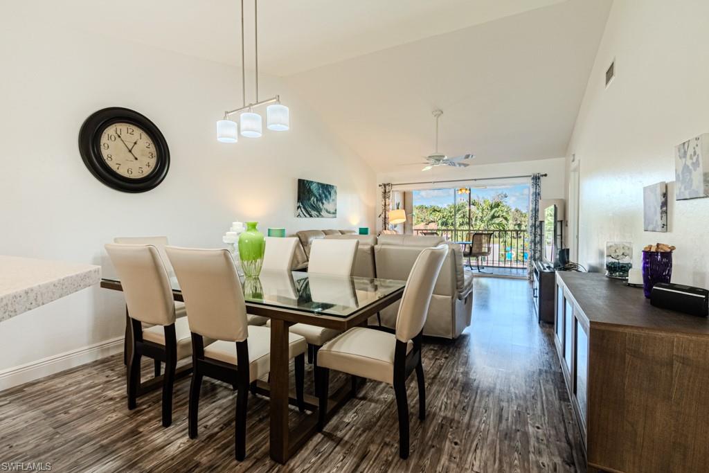 a view of a dining room with furniture a chandelier and wooden floor