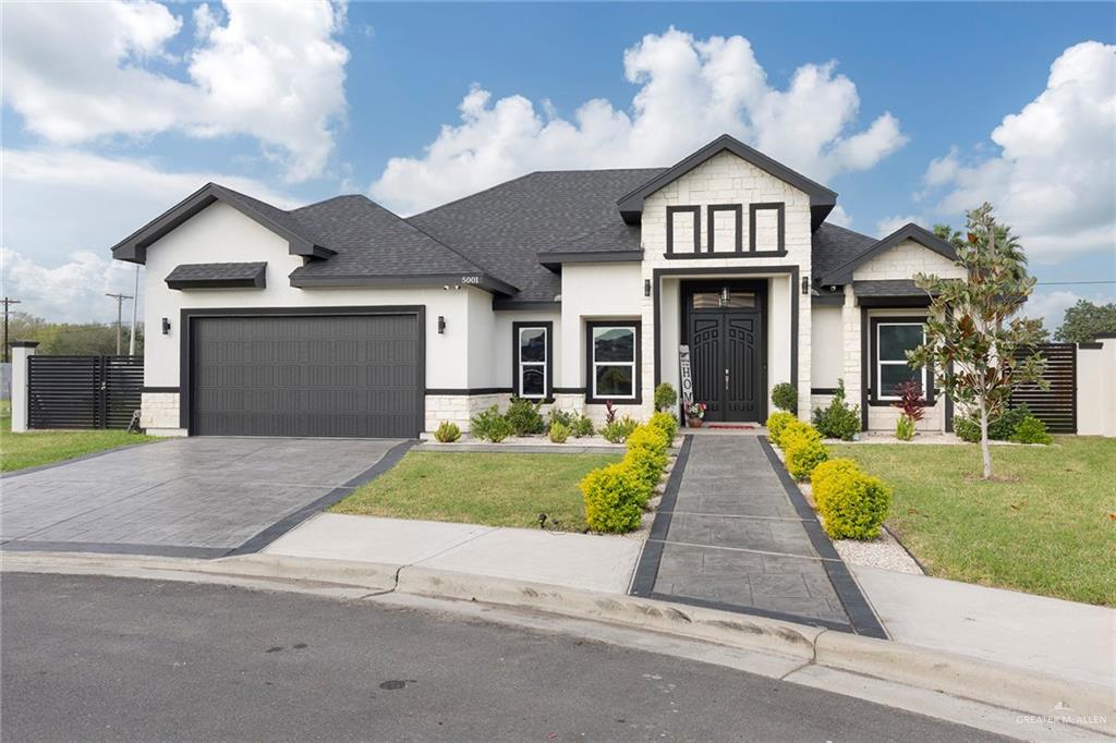 a front view of a house with a yard and garage