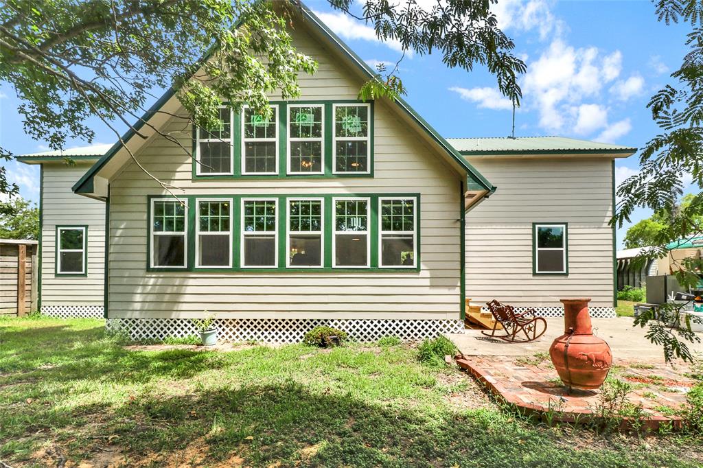 a front view of a house with a yard and potted plants