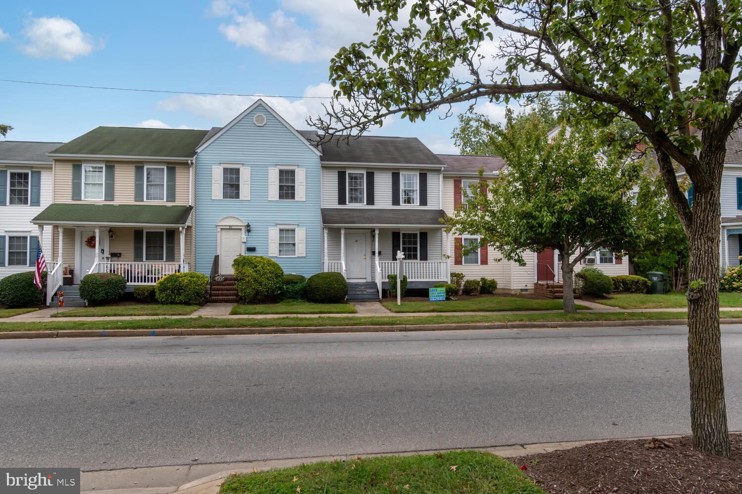 a front view of a residential houses with yard and green space