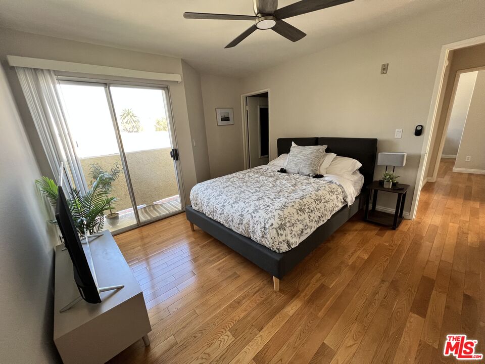 a bedroom with a bed window and wooden floor