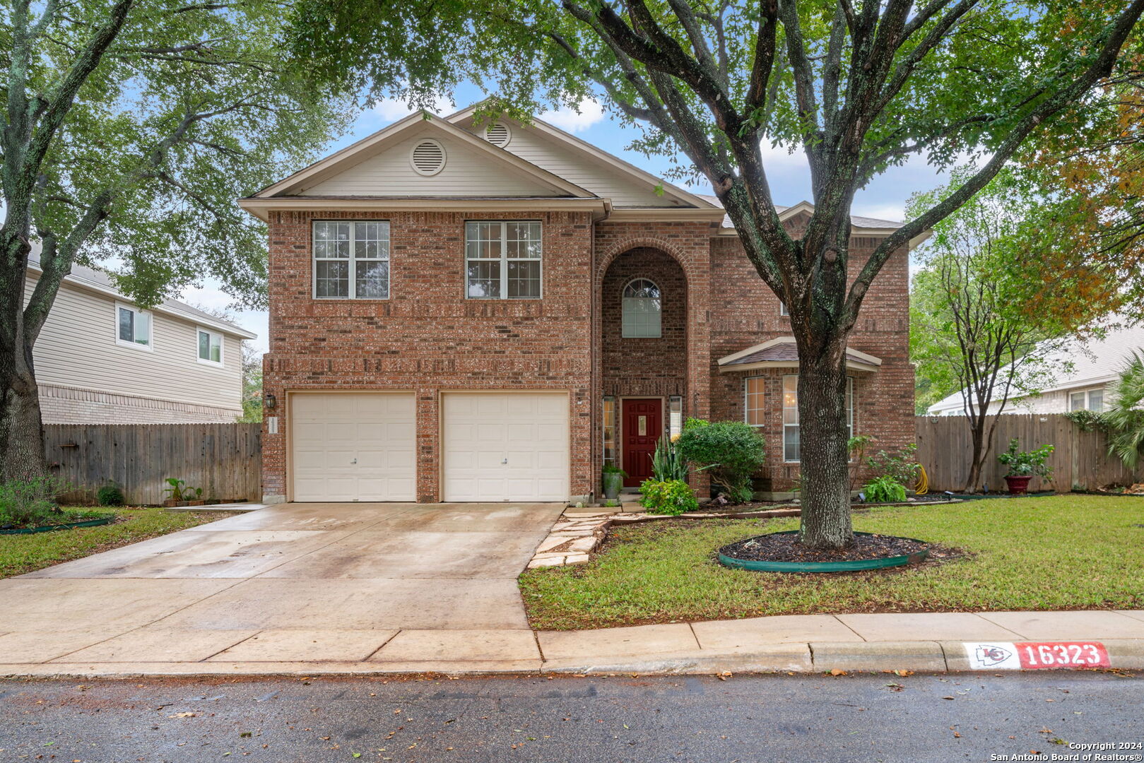 a front view of a house with a yard and trees