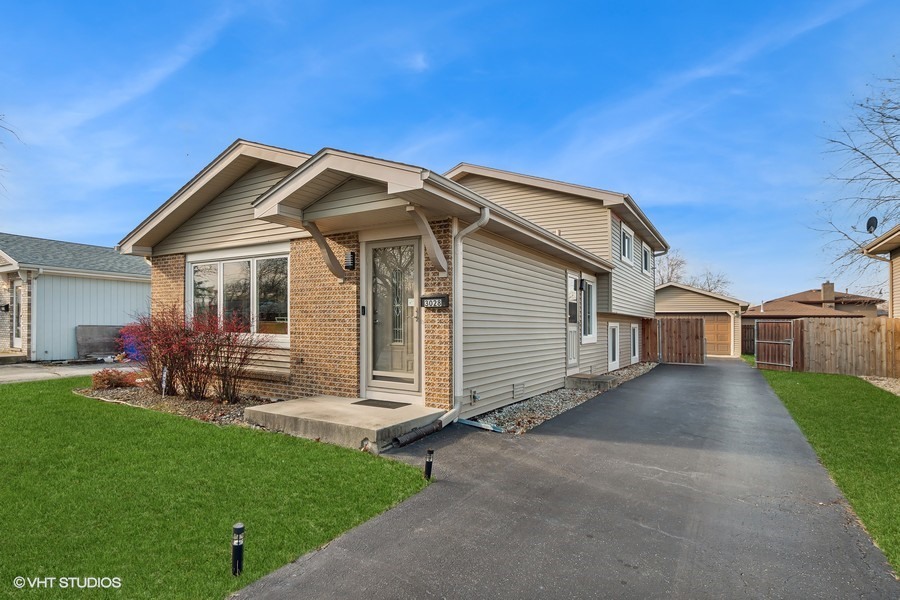 a front view of a house with a garden and yard