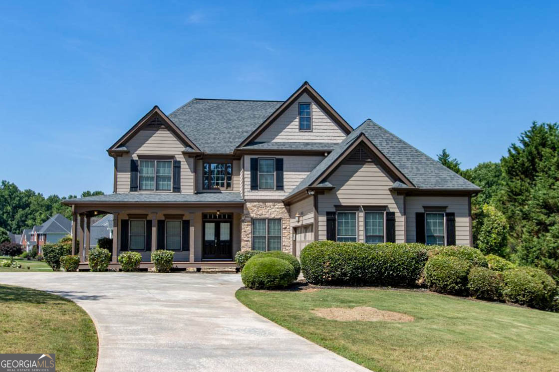 a front view of a house with yard and green space