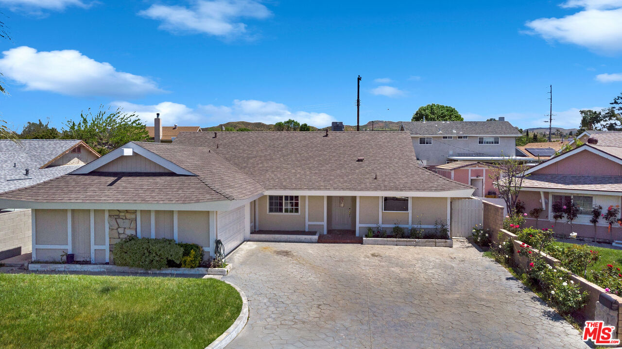 a front view of a house with a garden and yard