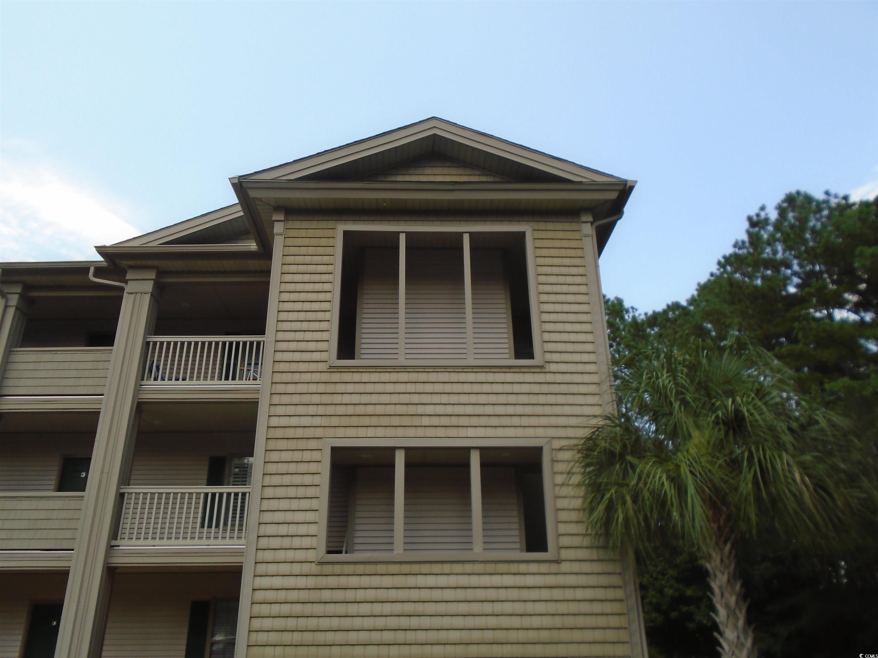 View of side of property with a balcony