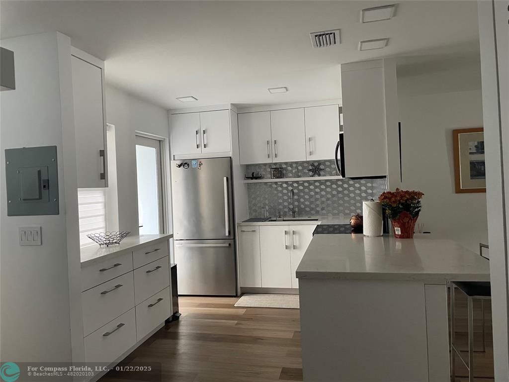 a kitchen with granite countertop a refrigerator stove and sink