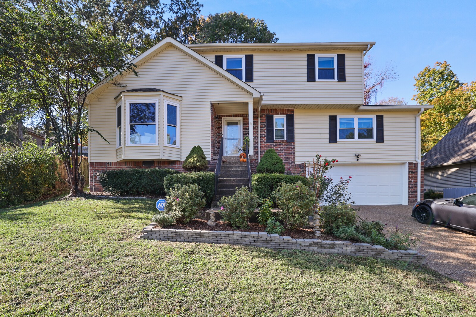 a front view of a house with a yard and potted plants