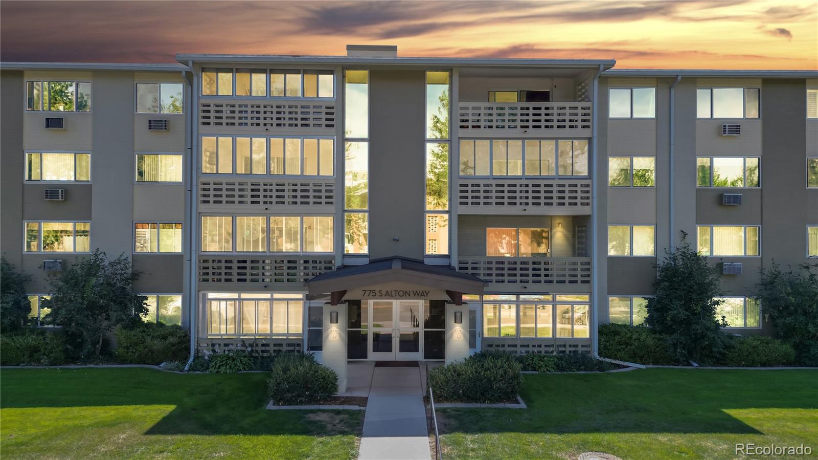 a front view of a residential apartment building with a yard