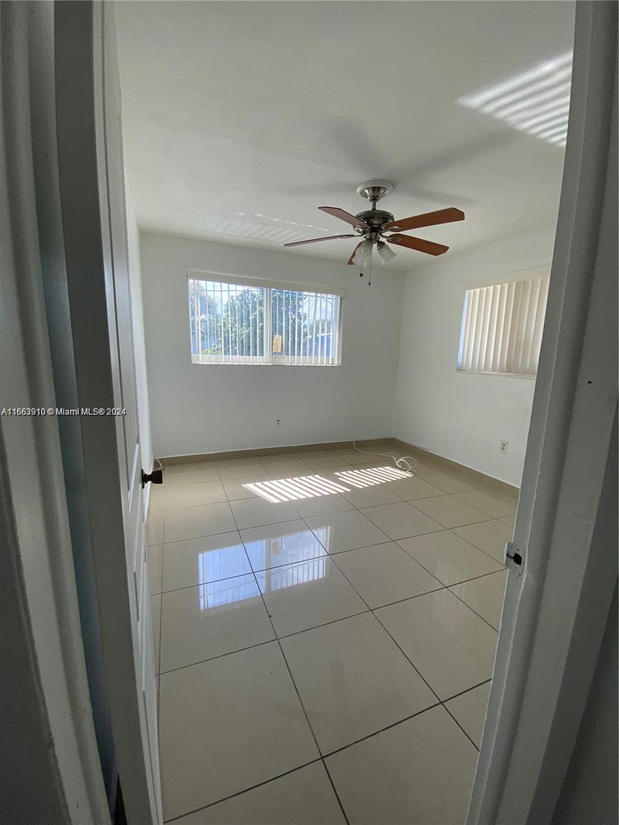 a view of a livingroom with a ceiling fan and window