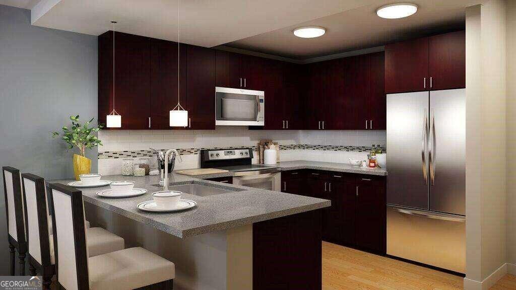 a kitchen with stainless steel appliances granite countertop a refrigerator a sink a stove a microwave and wooden cabinets