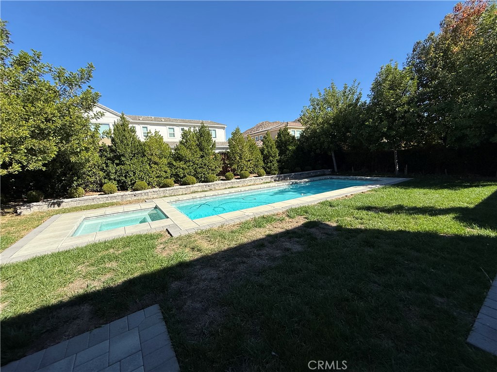 a view of a backyard with swimming pool and outdoor space