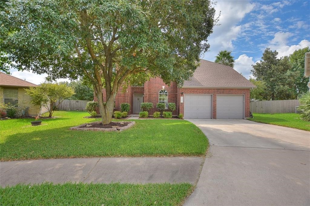 a view of a house with backyard and a tree