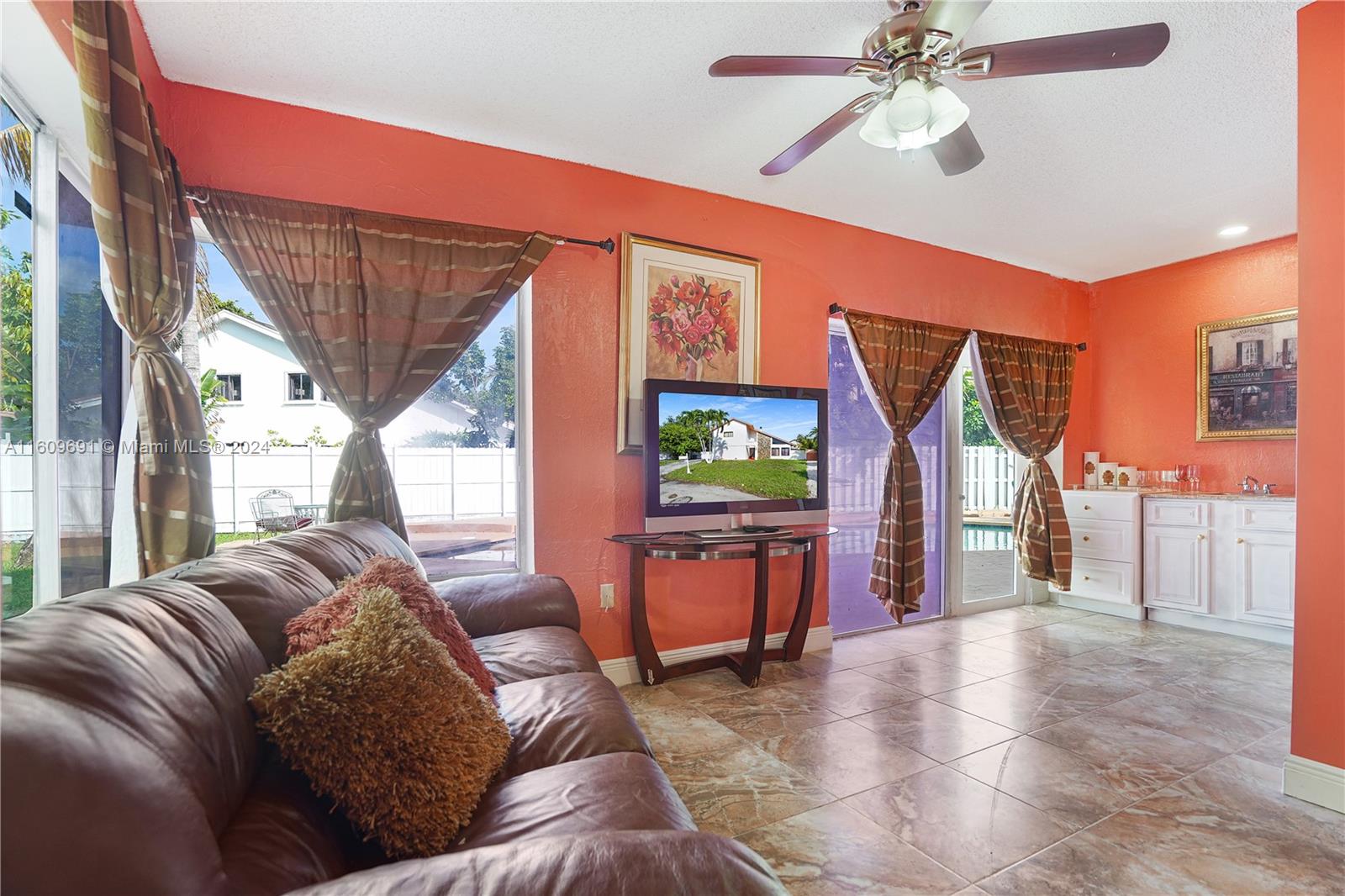 a living room with furniture a ceiling fan and a window