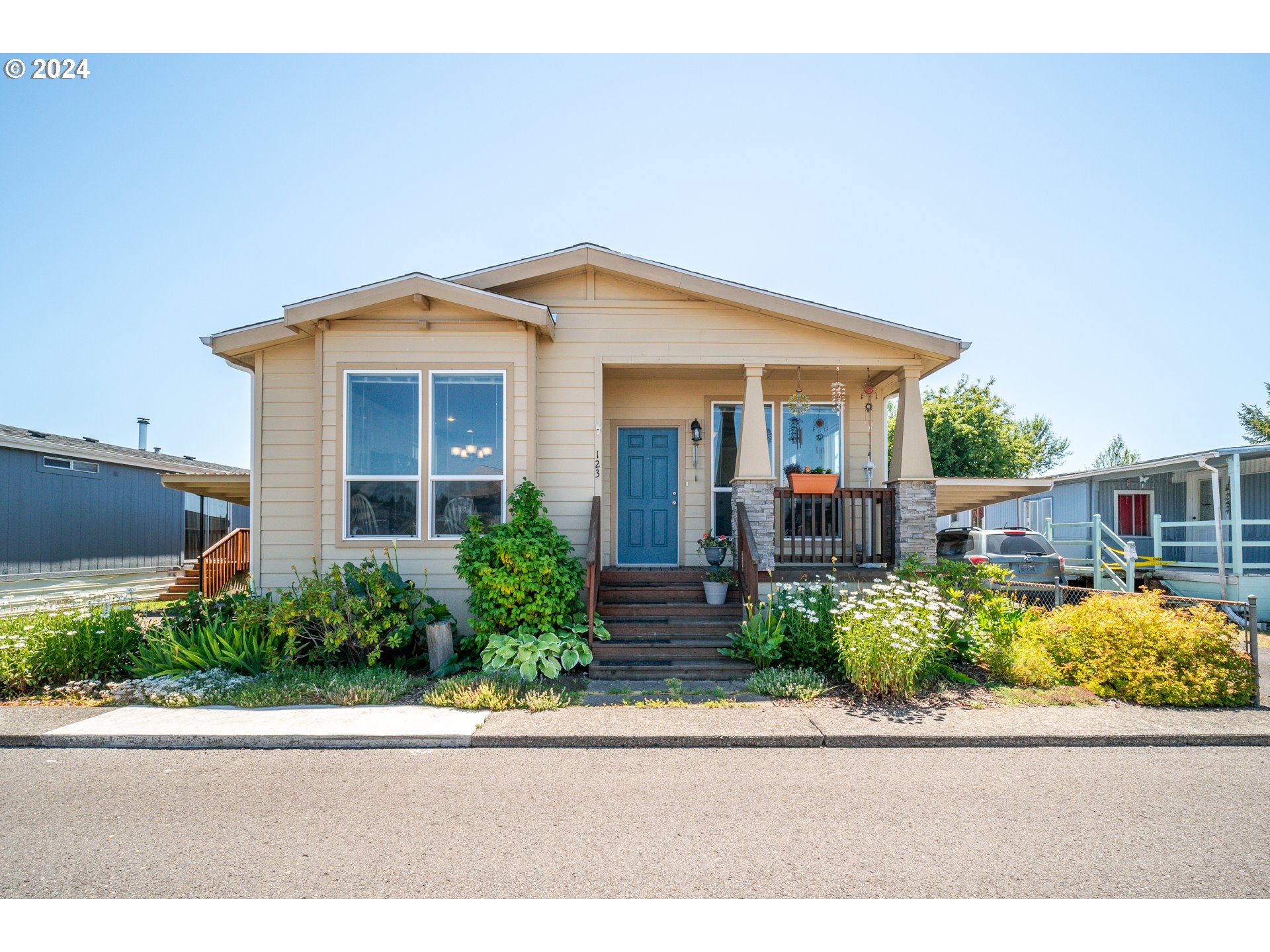 a front view of a house with a yard and potted plants