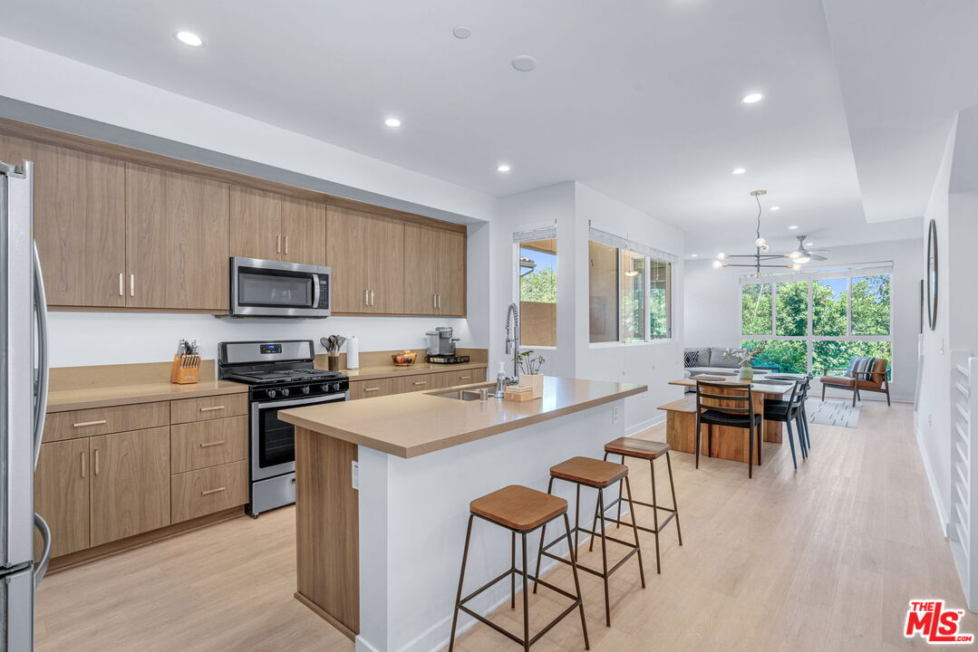 a kitchen with a table chairs microwave and cabinets