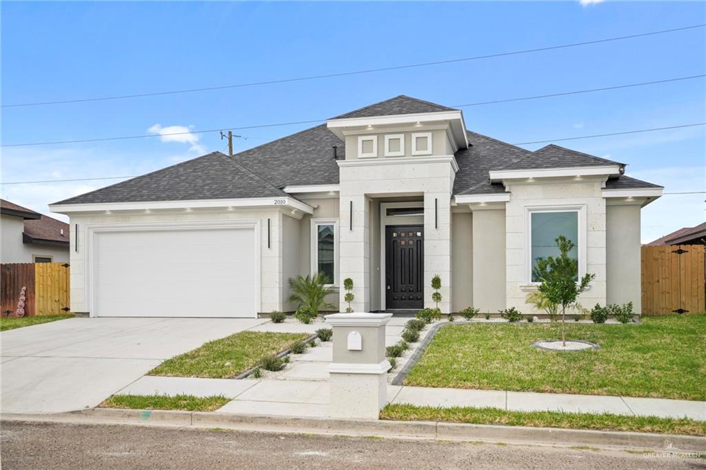 View of front of home featuring a garage and a front lawn