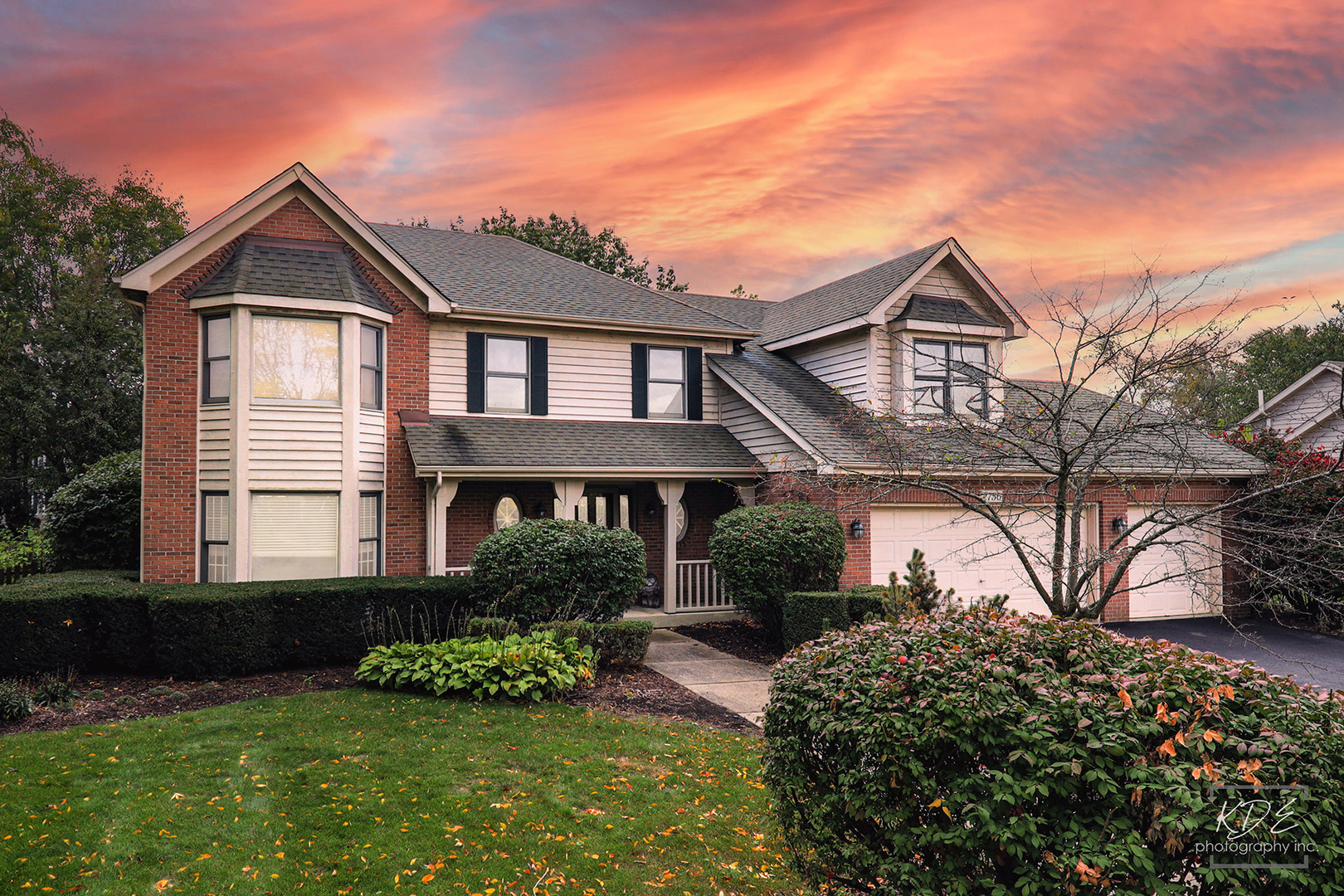 a front view of a house with a yard and potted plants