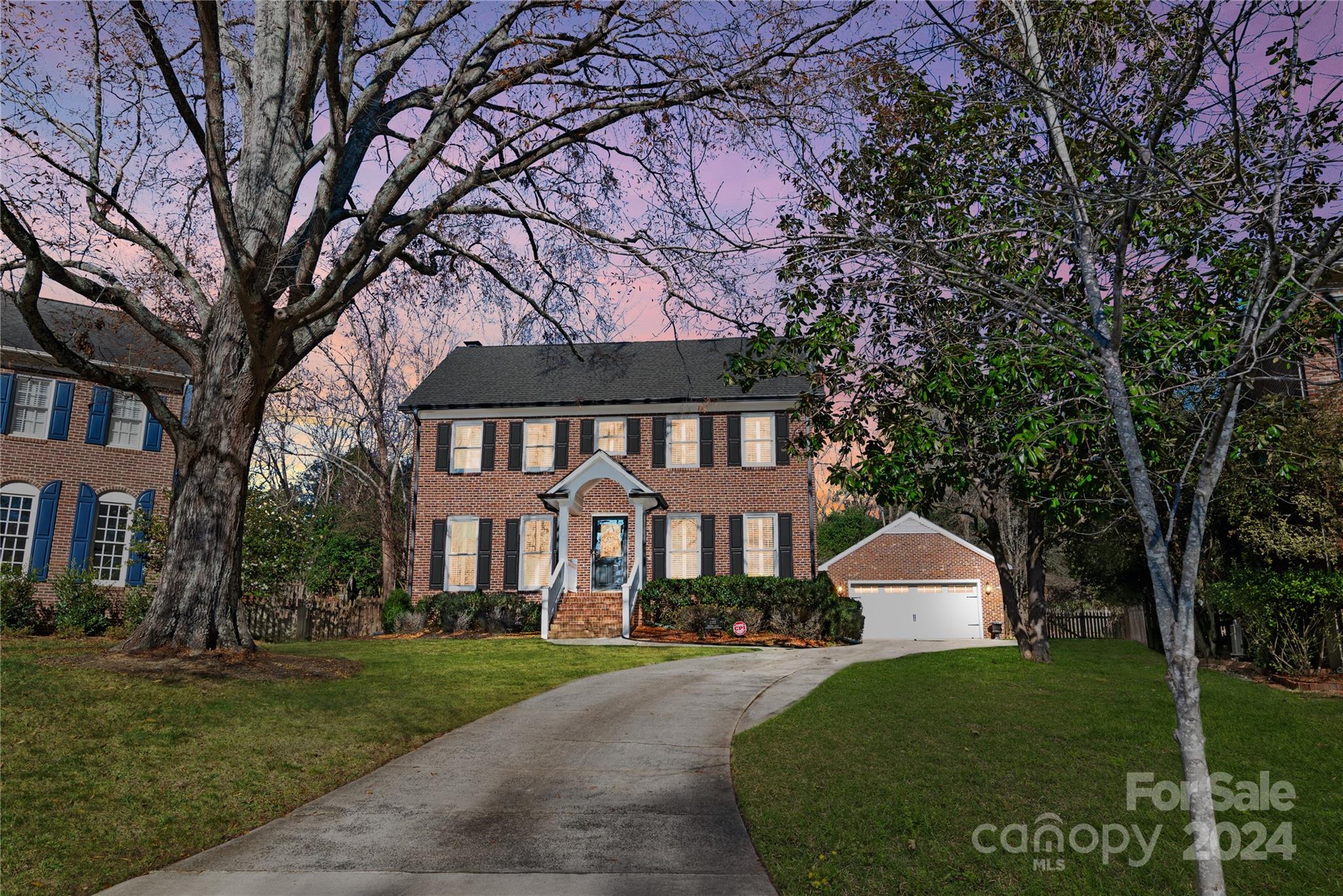 a front view of a house with a yard and trees