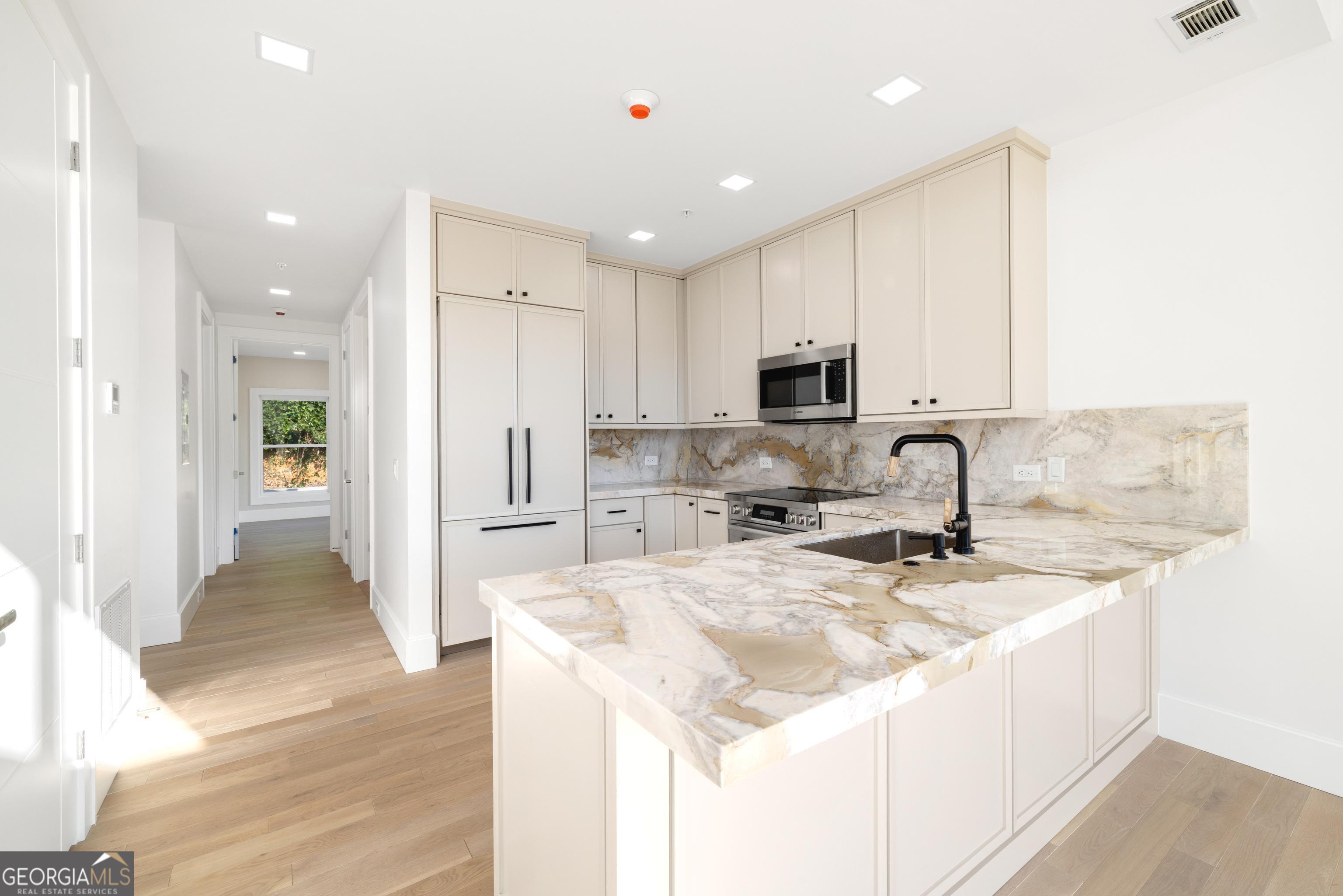 a kitchen with stainless steel appliances granite countertop a sink and a refrigerator