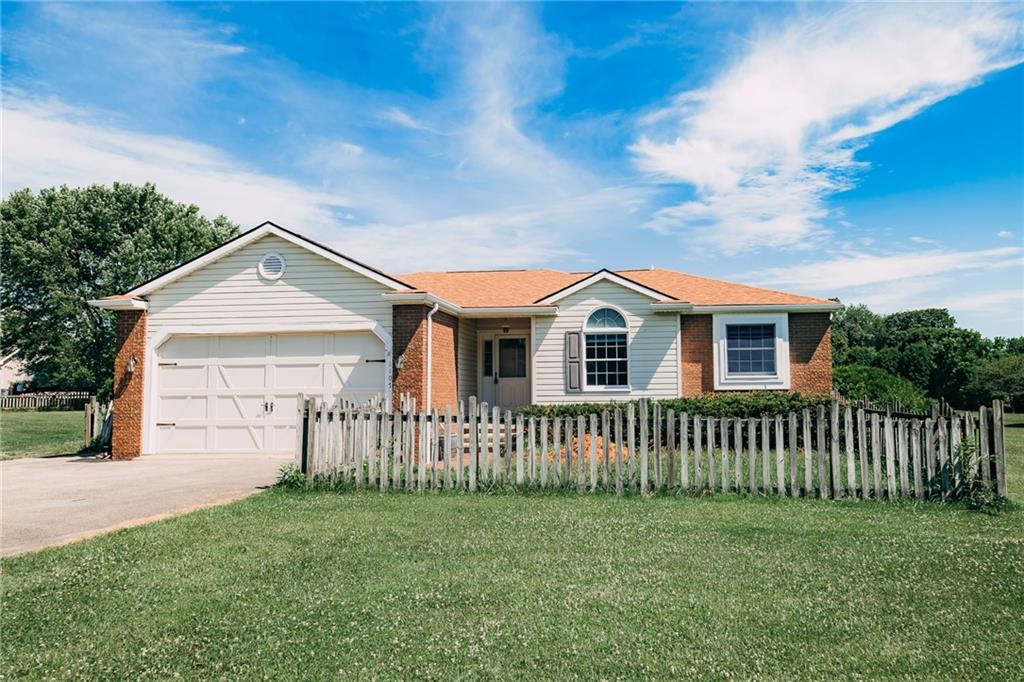 a view of a house with a yard and fence