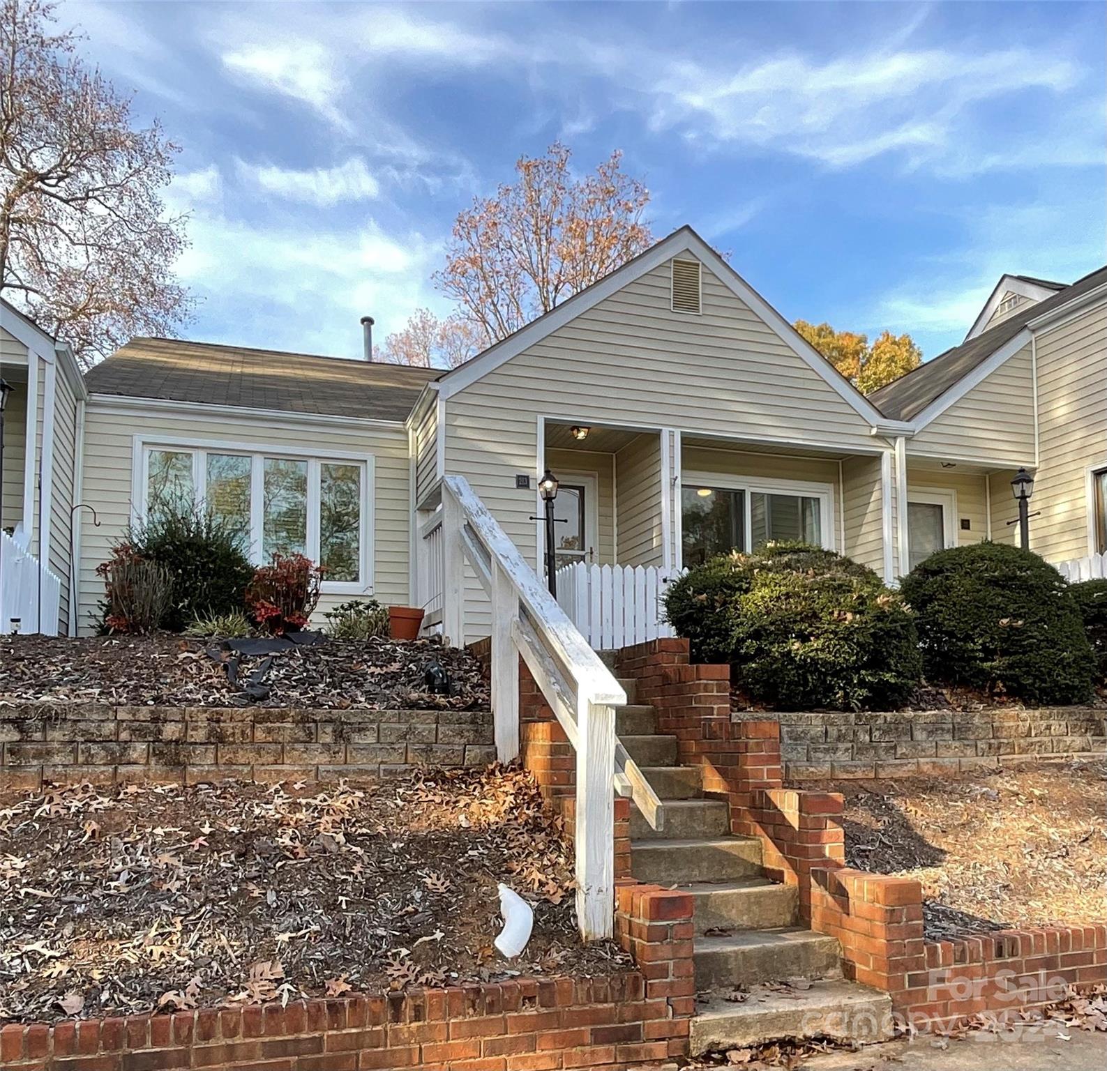 a front view of house with yard and trees in the background