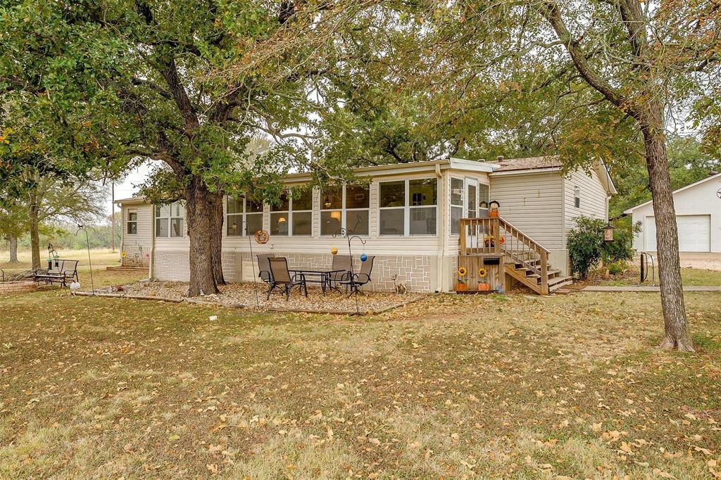 a view of a house with backyard and tree