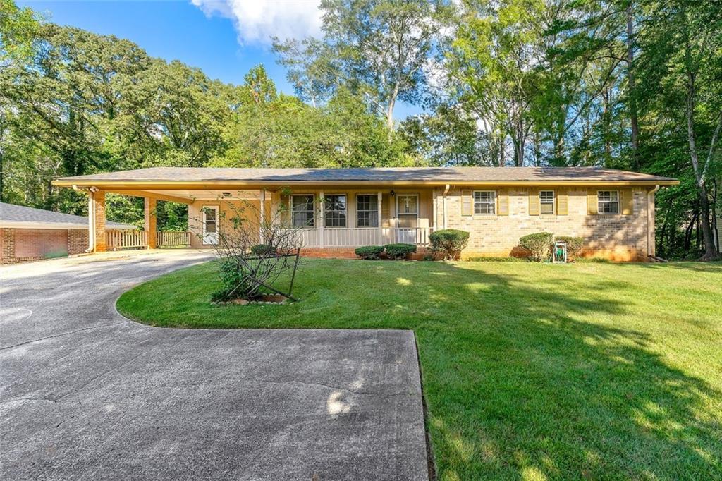 a front view of a house with a yard and trees