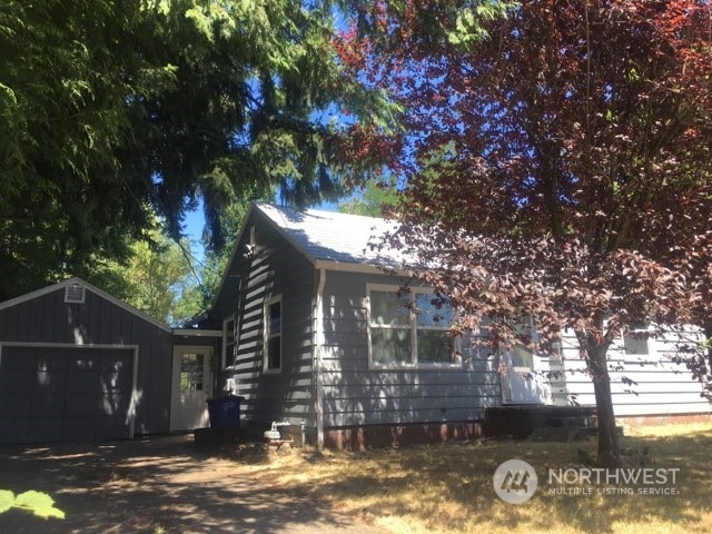 a view of a house with a yard large tree and a tree