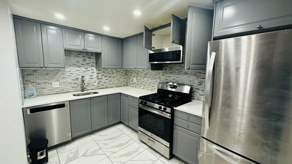 a kitchen with stainless steel appliances granite countertop a refrigerator sink and stove