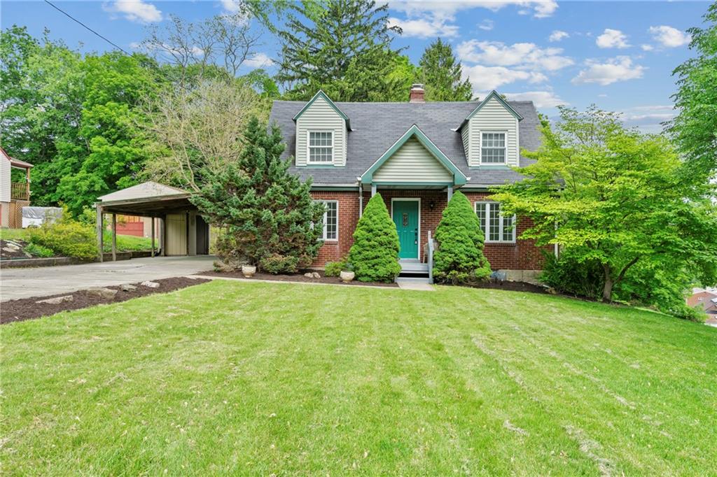 a front view of a house with a yard and trees