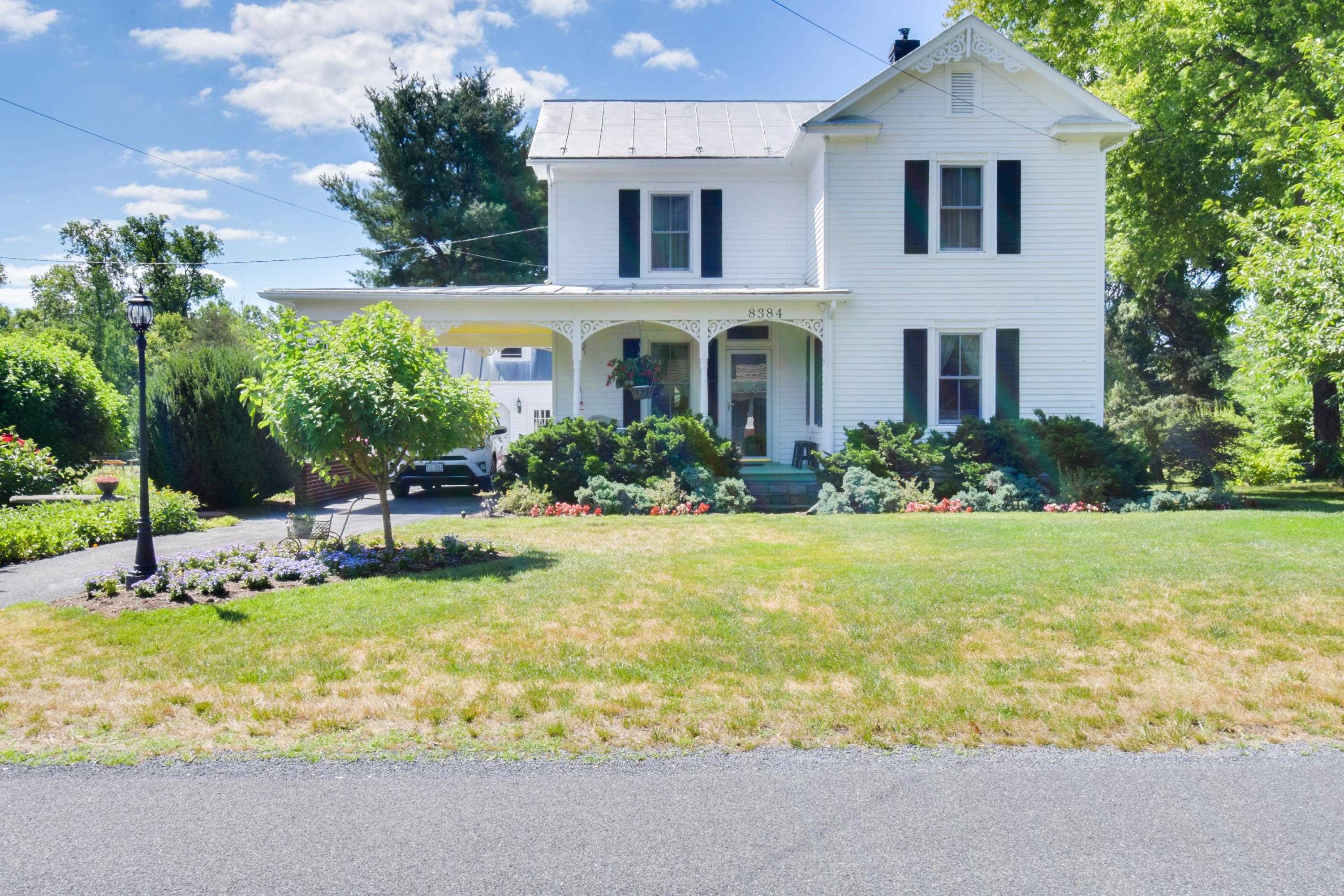 a front view of house with yard and trees in the background