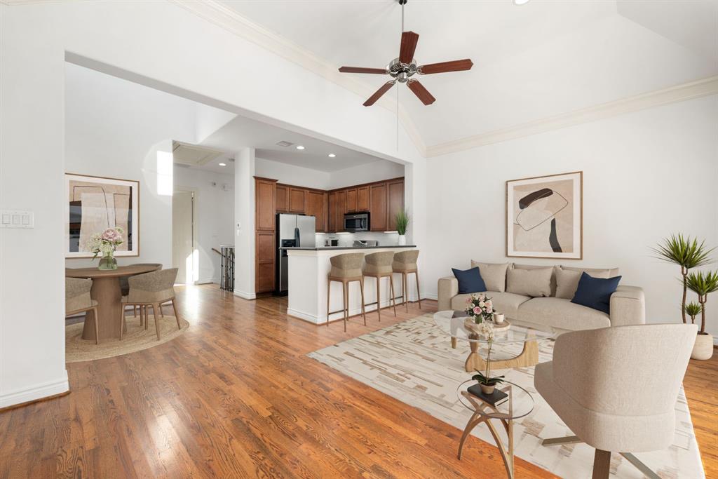 a living room with furniture kitchen view and a wooden floor