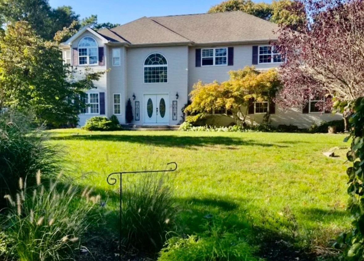 Colonial inspired home featuring a front lawn