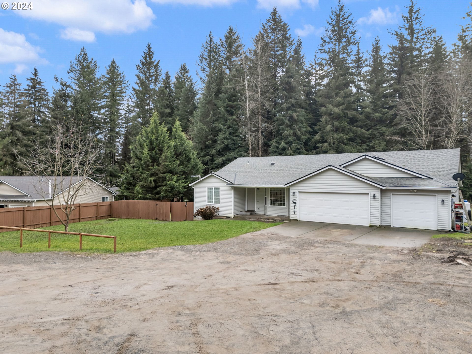 a view of a house with a yard and large trees