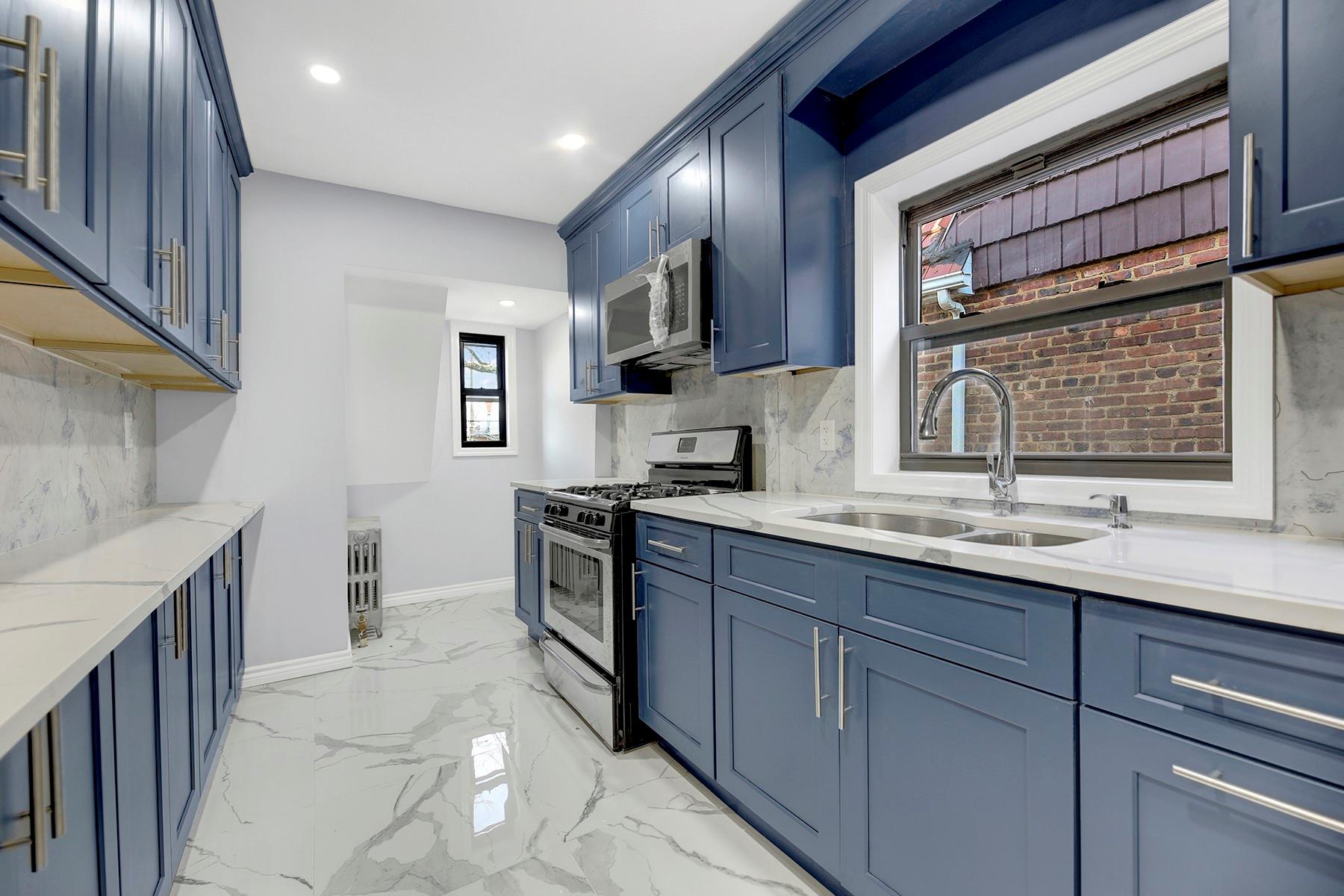 Kitchen featuring sink, light stone countertops, stainless steel appliances, and tasteful backsplash