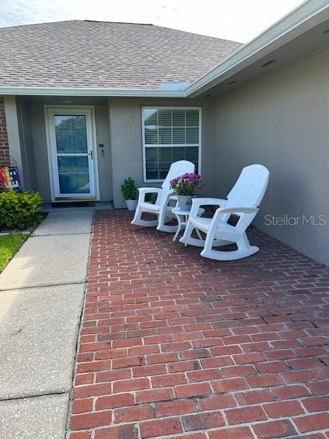 a front view of a house with a chairs and table in a patio