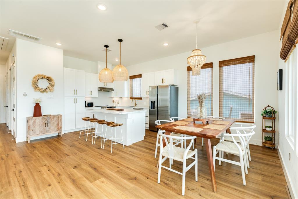 a room with stainless steel appliances kitchen island granite countertop a dining table and chairs