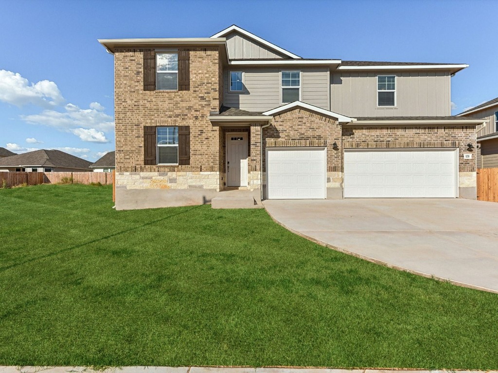 a front view of a house with a garden and yard