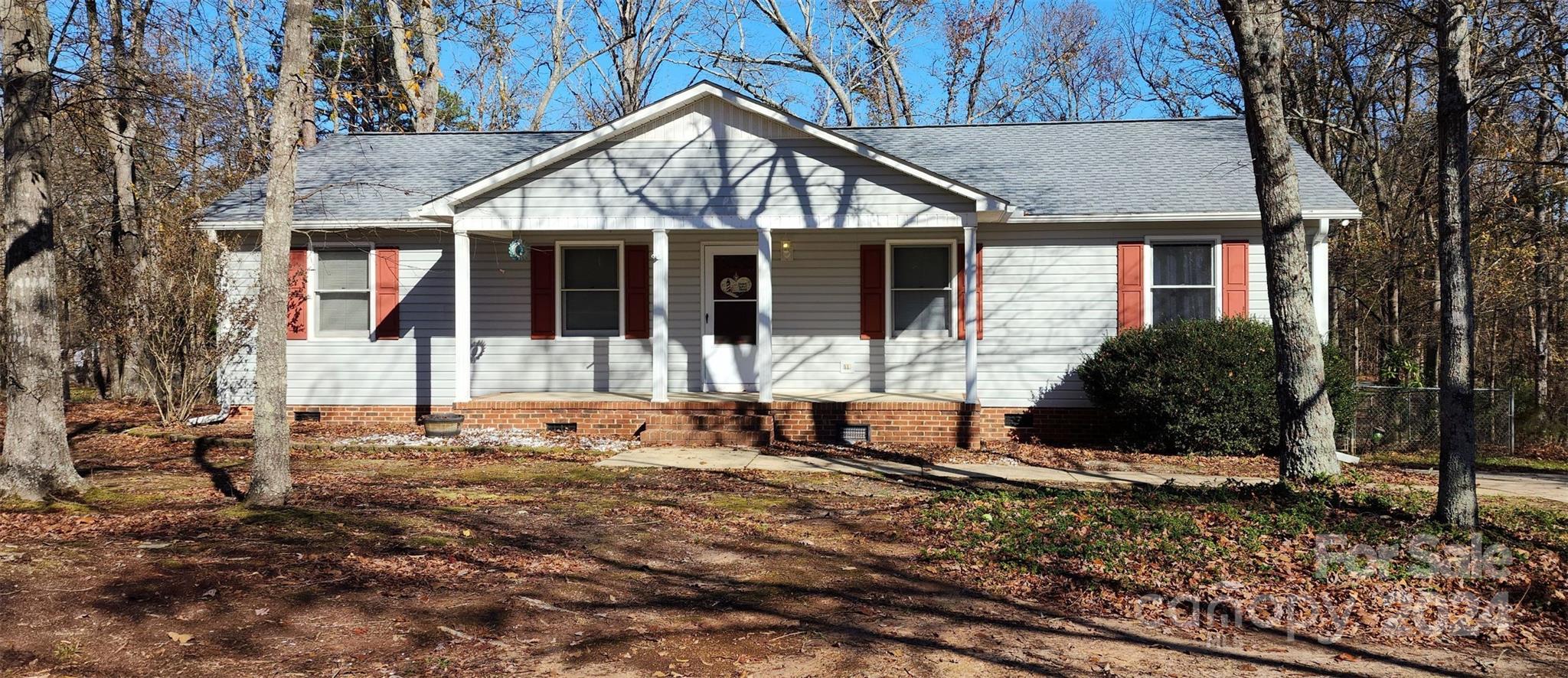 a view of a house with a yard and large tree