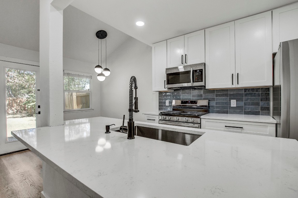 a kitchen with stainless steel appliances a stove sink and cabinets