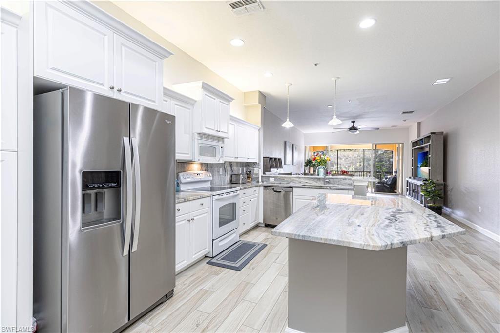 a kitchen with a refrigerator a sink and cabinets