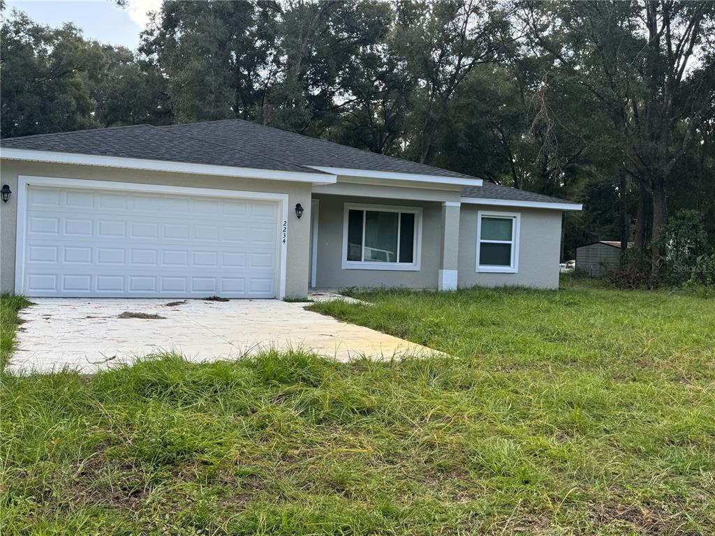 a view of a house with a yard and garage