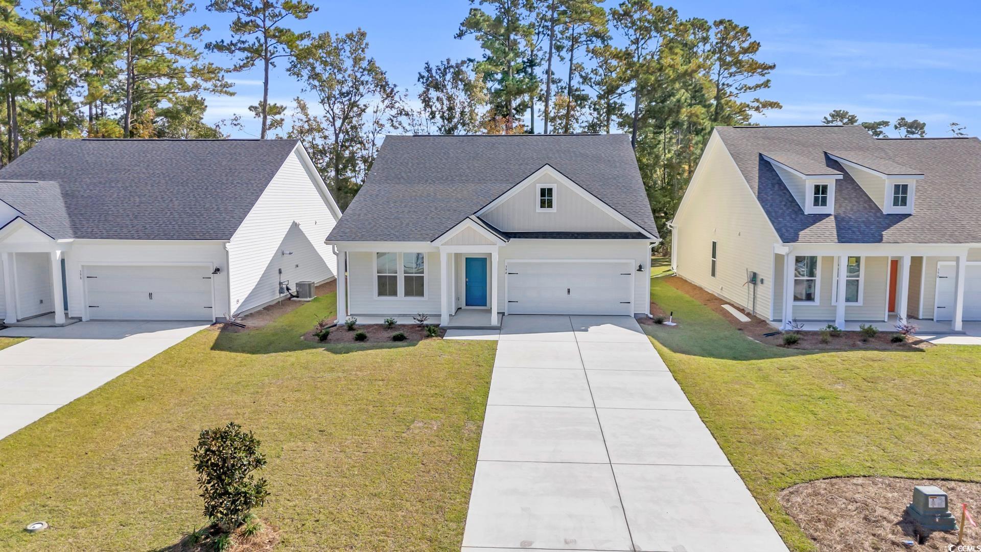 View of front of house with a garage and a front y