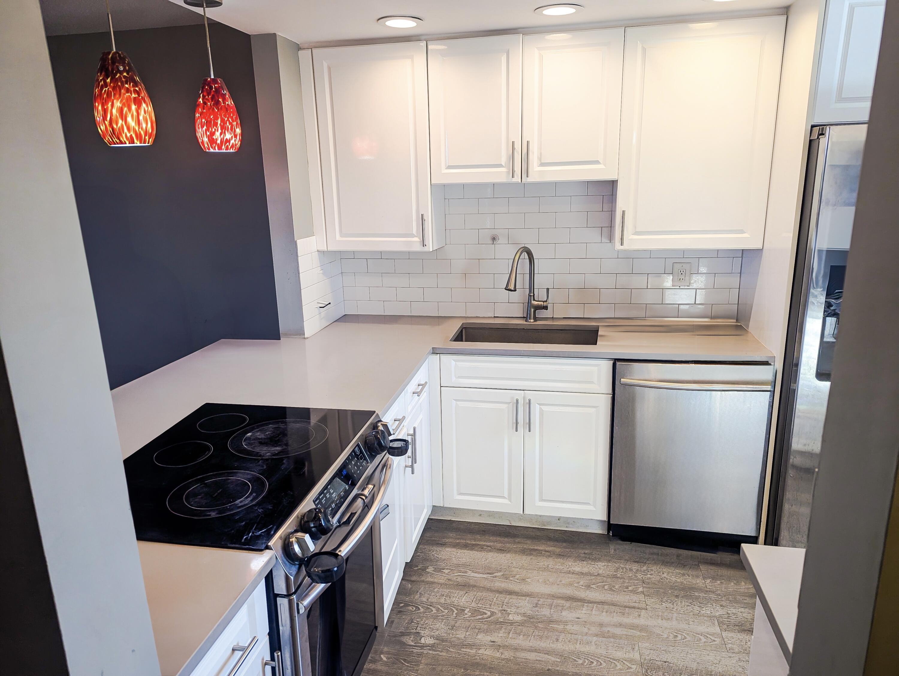 a kitchen with stainless steel appliances granite countertop a sink stove and refrigerator