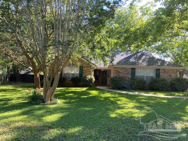 a front view of a house with a yard and trees